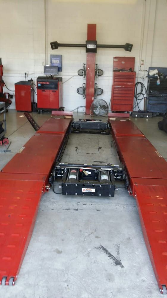 An alignment bay with a red runway lift and alignment equipment